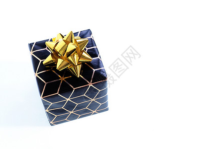 几何的白色带有黄金几何图案和弓的黑包装纸小盒子中的黑包装纸白色背景上的孤立线条图片
