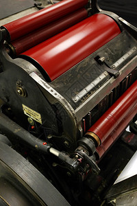 一台旧风车印刷机的老图象剪切机编号器上面有亮红墨水颜色明的滚筒图片