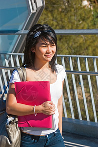 粉色的杯子年轻笑亚洲学生拿着粉红色夹子并戴头巾黑发图片
