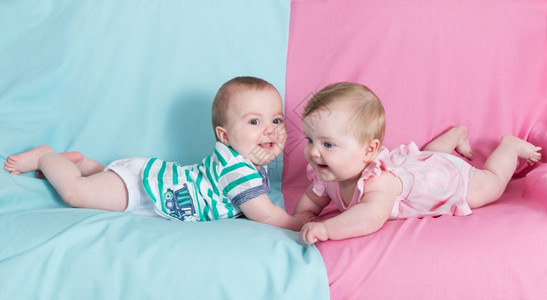 支持双胞胎女孩和男粉红蓝色背景可爱的快乐图片