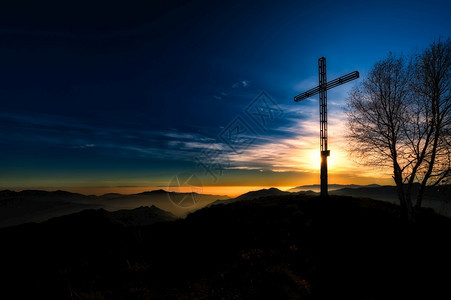 沉思的在日落宗教冥想气氛下山顶横跨峰爬坡道天主教图片