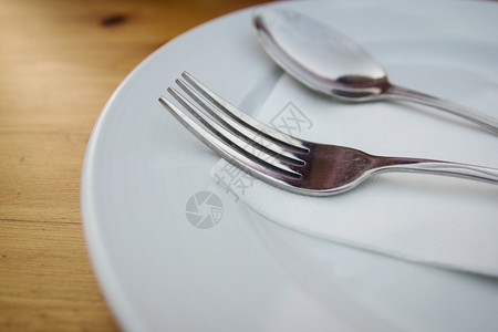 闪亮的陶瓷制品现代将白板叉子和勺放在木板上图片