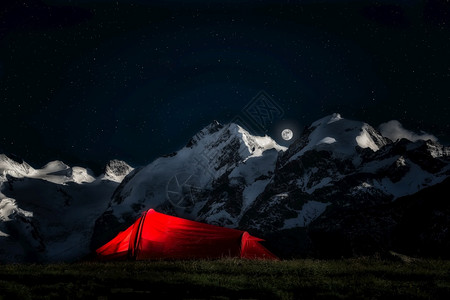 星星火炬满的孤独撤退为冒险登山者准备的帐篷夜里深在天空中满月的星冰山底背景