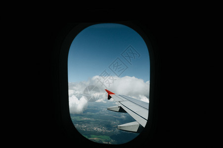 航班美丽的景色城市通过飞机窗口对日落的景色观视从空中与风翼蓝色天空和云彩美丽飞行机翼的窗口中看到机窗口的图像保存路径蓝色的天际线图片