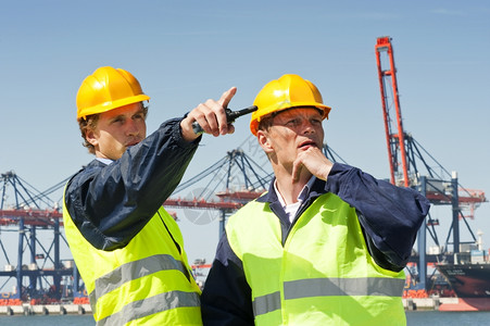 码头工人货物讨论中的两艘码头在一个大型工业港口的前面导师图片