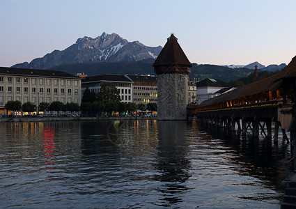 水吸引力Kapellbrucke教堂大桥是一座覆盖着的木桥跨越瑞士卢塞恩市的鲁斯河位于日落的礼拜桥皮拉图斯图片