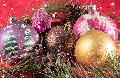 松树多彩圣诞球和松果节球躺在树枝上底模糊的本锥体新图片