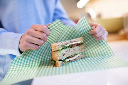 裹塑料在可再利用环境友好型比斯瓦克环球包装中将女扎三明治贴近厨房图片