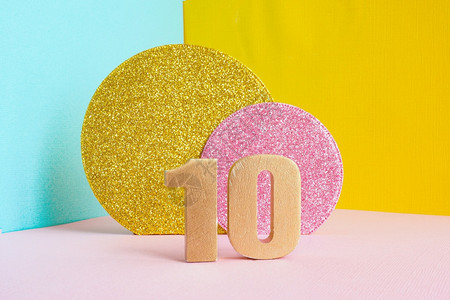 10号金黄在多色蓝粉和两颗闪亮金子粉红色圆圈的蓝黄粉背景上祝生日贺卡概念快乐一种明亮的信片图片
