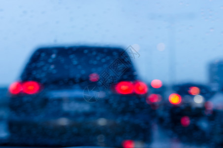 降低路上的模糊汽车交通堵塞着雨滴挡风玻璃暴图片