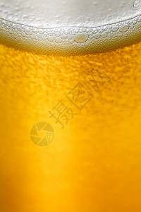 凉爽的黄色喝软饮料气泡升到水的表面紧闭着玻璃背景图片