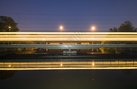 夜间在铁路桥上进行城市间赛车模糊低的乘客图片
