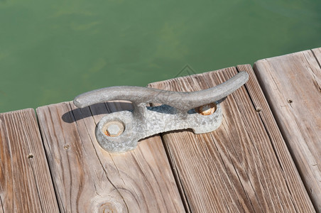 水户外泊木制码头绿色环礁湖上的旧铁系固克拉图片