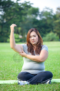 皮肤年轻的亚洲胖女人检查她的手臂脂肪不良图片