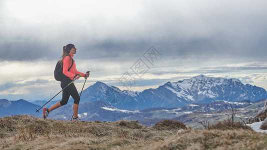 运动的一个在山上独自行走的北欧步女孩积极的图片