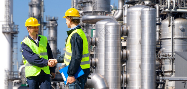 工程师两个石油化工承包商在石油炼厂前完成一项交易化学正面图片