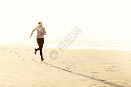 运动女孩速度美丽健康的女人在沙滩上奔跑图片