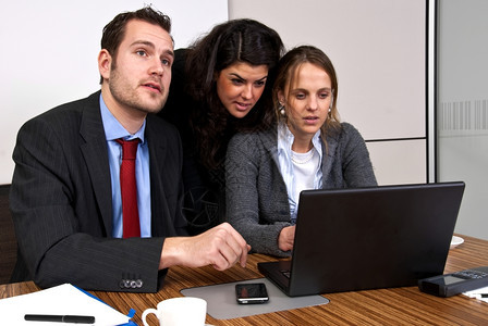 男人会议三名工作员在浏览笔记本电脑时讨论财务事项同时浏览笔记本电脑移动的图片