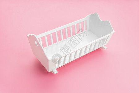 学步的儿童保护以粉红背景隔离的白色婴儿床女孩出生率概念自在图片