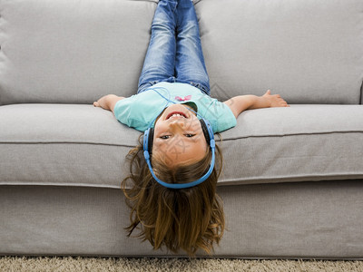 躺在沙发上玩耍的小女孩技术高清图片素材