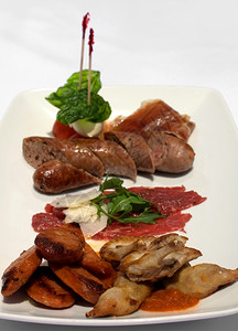 红色的盘子牛肉Entree选择板供烤奎尔意大利香肠比夫卡帕西奥普罗图托马和博科尼图片