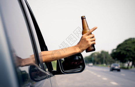 阿奥尔斯柯手在街上驾车时拿着一罐酒玩忽职守鬼车辆危险图片