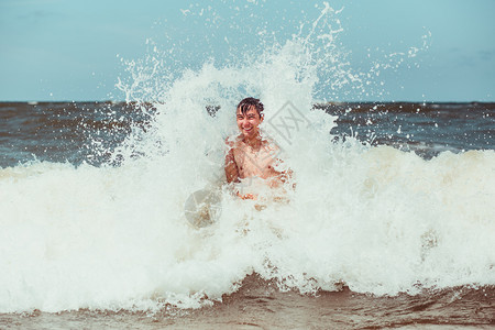 请享用年轻人在暑假期间享受海浪的盛大风在海上渡暑假时过闲暇经图片