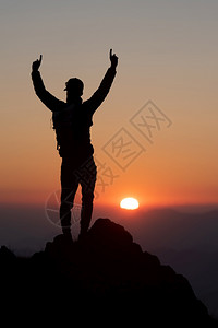 首脑攀登山者在日落时征服高峰会顶图片