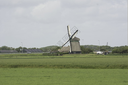 荷兰如画乡村土丘风车以绿草地为前景图片