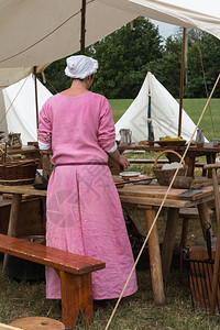 素食主义者营养饮粉红图尼克女人准备黑锅在帐篷里煮饭图片