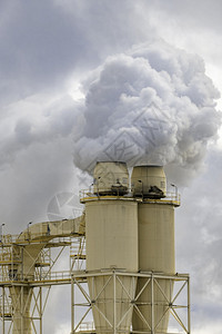 抽烟棕色的堆栈在一个区域乡镇的大型制造设施在加工过程中从烟囱堆抽取蒸汽的废气图片