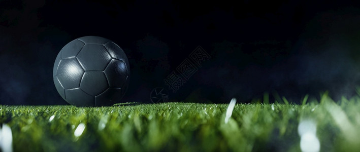 标题黑球在足场绿草地上以暗底背景为复制空间的黑色足球低角紧贴地面活动图片