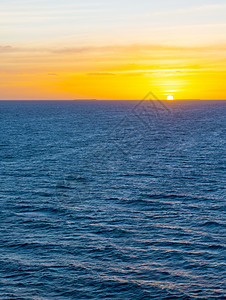 户外黎明海面上日落平线直和温柔的海洋波浪云背景图片