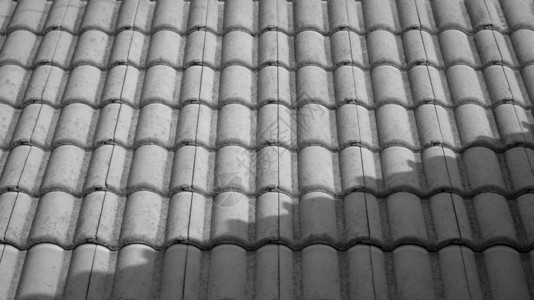 外部的黑色和白旧瓷砖屋顶表面黑白风格的覆盖图案阳光和阴影户外黑色的图片