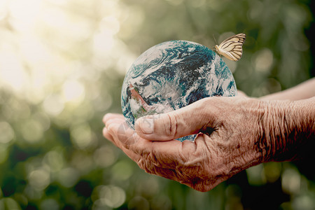 地球环境的一种旧女人手握着一个环球上面挂着白蝴蝶生态概念美国航天局提供的这张图片元素图片