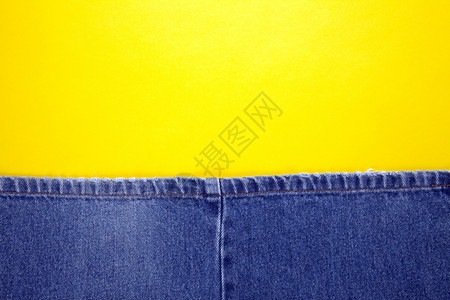 垃圾摇滚纤维蓝牛仔裤有黄针和色背景抽象的图片