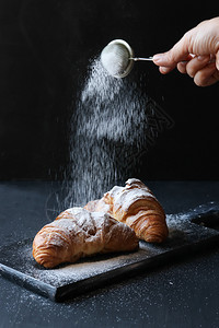 一种甜点桌子黑色背景的Croissat图片
