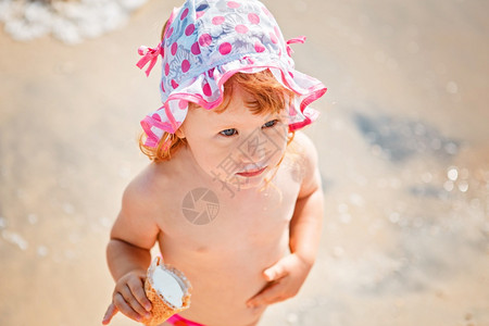 胃假期海岸可爱的小女孩吃冰淇淋在海滩度假图片