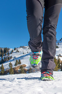 在雪上漫步穿着靴子和短裤走在雪上安全攀登尖峰图片