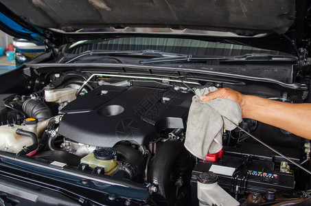 人们服务工检查油层的汽车修理机图片