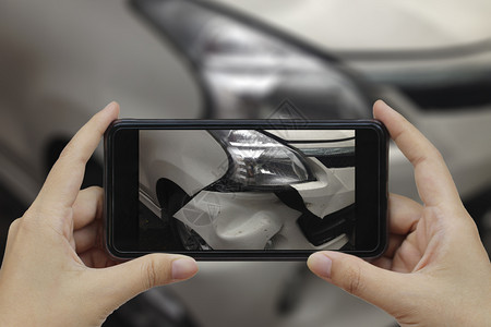 手持智能机在车祸现场拍一张相片发生车祸和人们辆场景图片