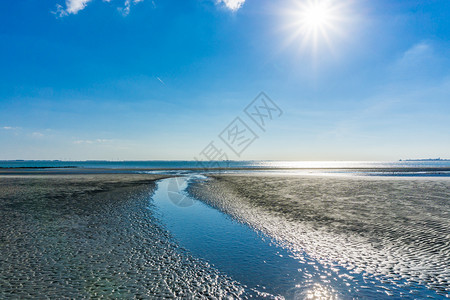 湖海滩上阳光明媚的一天从海中分出河流云裂的图片