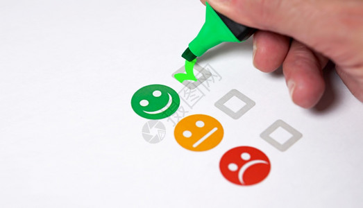 客户满意的反馈度评级清单和优秀的商业质量评价概念由客户亲手检查绿色微笑的表情脸像贴近视景Gre绿笑脸回馈快乐的消费者背景图片