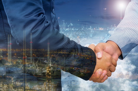 男人相信商握手和工业背景的双重曝光商人的双重曝光城市图片