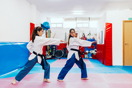 老师中央韧有两个年轻妇女在一培训中心里练习泰拳道图片