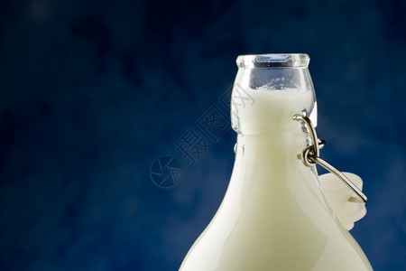 可口蓝色背景面前的牛奶瓶照片好饮料图片