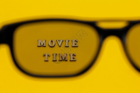 自由家放松通过黄纸背景上的3D眼镜关注文本电影时间概念和娱乐通过黄纸背景上的图片