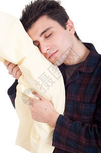 穿着睡衣的沉青年男子抱着白背景孤立的枕头快乐保持图片