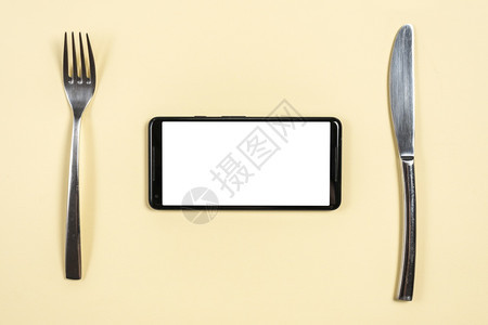 桌面上摆放的餐具和手机图片