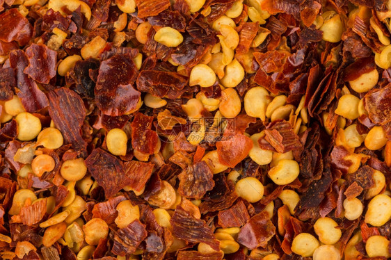 辛辣的土耳其草本植物一堆粉碎的红辣椒干片和种子作为背景图片